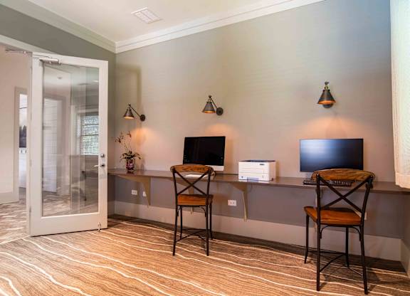 a room with a desk with two chairs and a television at Century New Holland, Gainesville, GA, 30501