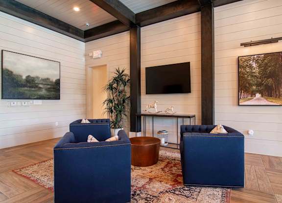 a living room with blue chairs and a tv at Century New Holland, Gainesville, Georgia