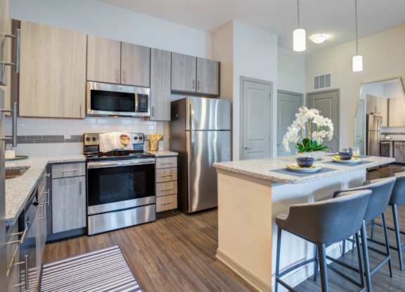 an open kitchen and dining area with stainless steel appliances and a table with chairs at Century Town Center, Florida, 32607