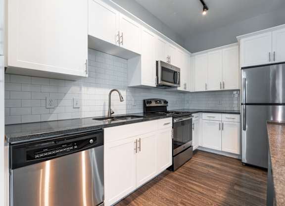 A kitchen with white cabinets and a black stove top.at Century Baxter Avenue, Louisville Kentucky