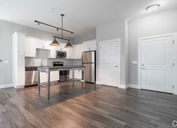 A modern kitchen with a wooden floor and white walls.at Century Baxter Avenue, Louisville Kentucky