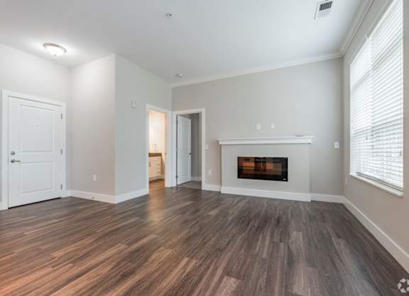 A room with a fireplace and wood flooring.at Century Baxter Avenue, Louisville Kentucky