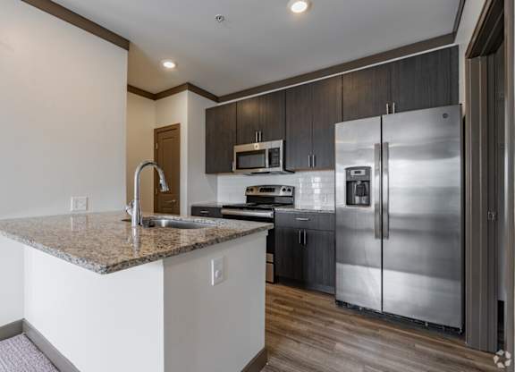 A kitchen with a granite countertop and stainless steel appliances. at Century Belmont Station, Louisville, Kentucky