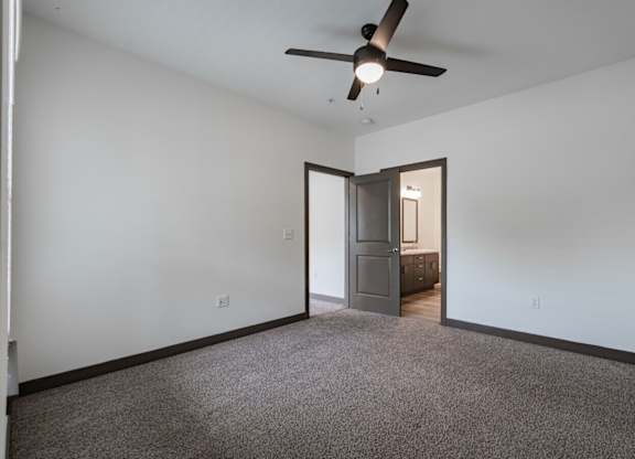 A room with a ceiling fan and a carpeted floor. at Century Belmont Station, Louisville, 40243