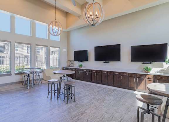 a large living room with tables and chairs and televisions at Century Palm Bluff, Portland