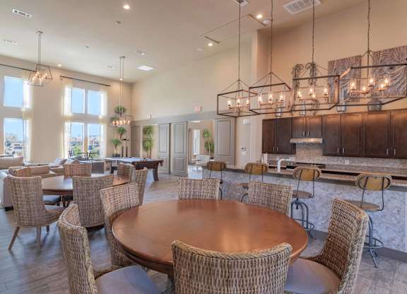 a large dining room with tables and chairs and a kitchen at Century Palm Bluff, Portland, Texas