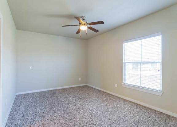 an empty room with a ceiling fan and a window at Century Palm Bluff, Portland, Texas