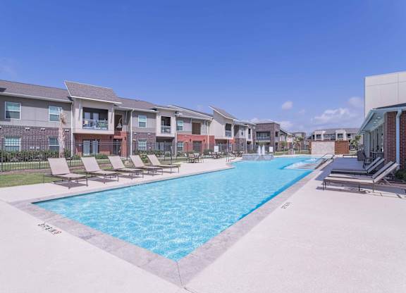 our apartments offer a swimming pool with lounge chairs at Century Palm Bluff, Portland, TX