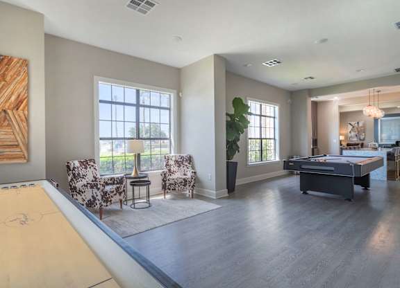 a living room with a pool table and two chairs at Century South Shore, League City, TX, 77573
