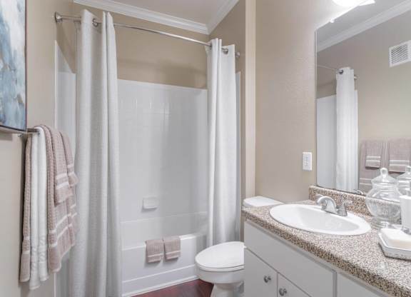 a bathroom with a shower toilet and sink at Century South Shore, League City