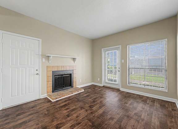 A room with a fireplace and a window with blinds.