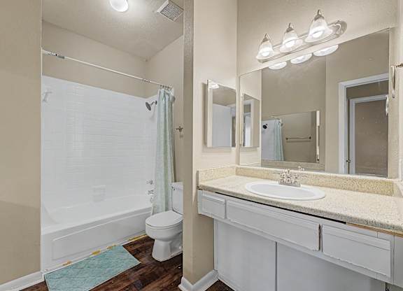 A white bathroom with a toilet, sink, and shower.