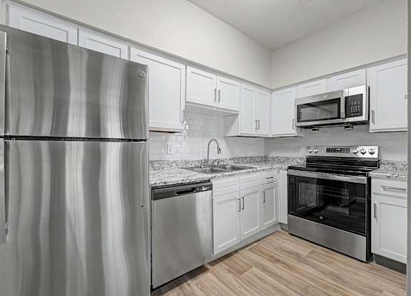 A kitchen with a stainless steel refrigerator and oven.