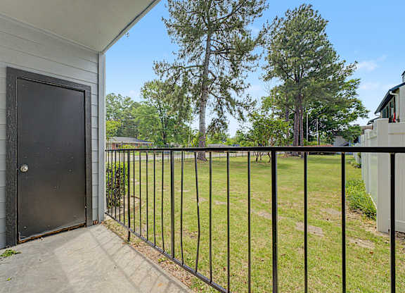 A black door is on the left side of a white house.
