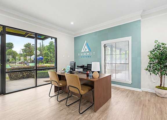 A room with a desk and chairs with Summit sign on the wall.