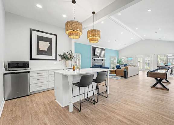 A modern kitchen with a white island and bar stools.