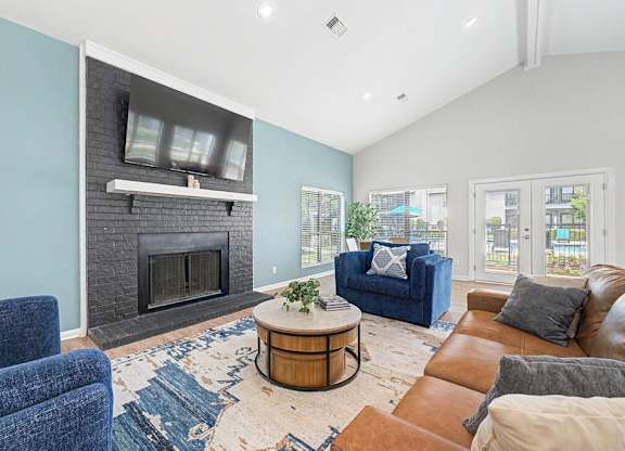 A living room with a fireplace and a blue couch.