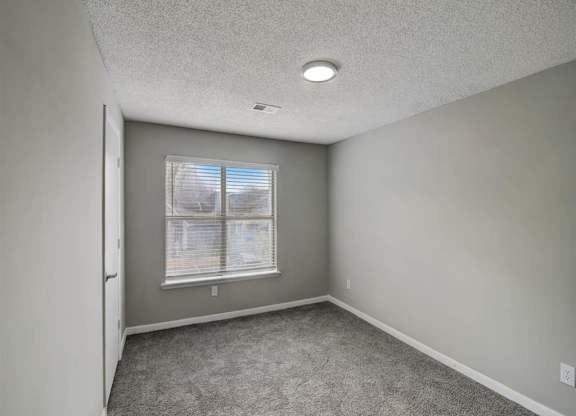 an empty room with a window and carpet at The Sapphire, Decatur, 30035