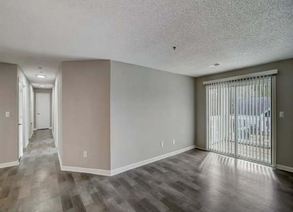 a living room with a sliding glass door to a balcony at The Sapphire, Georgia, 30035