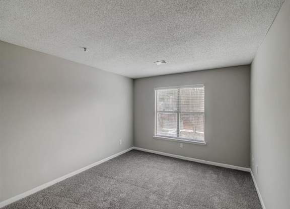 an empty living room with a window at The Sapphire, Decatur, 30035