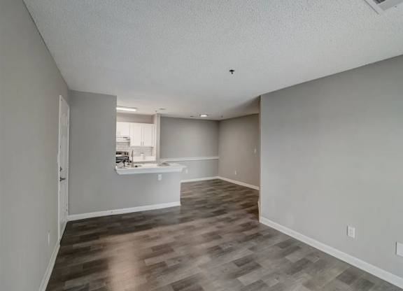 an empty living room and kitchen with a hard wood floor at The Sapphire, Decatur