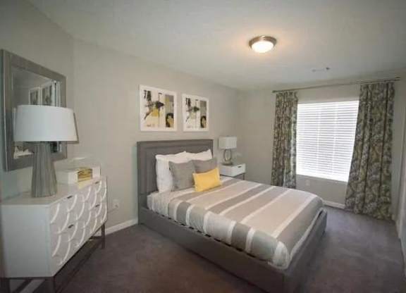 a bedroom with a bed and a dresser and a window  at The Sapphire, Georgia, 30035