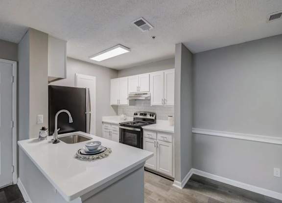 a white kitchen with a sink and a refrigerator at The Sapphire, Decatur