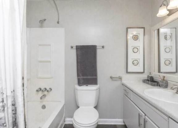 a white bathroom with a toilet and a sink at The Sapphire, Decatur, GA, 30035