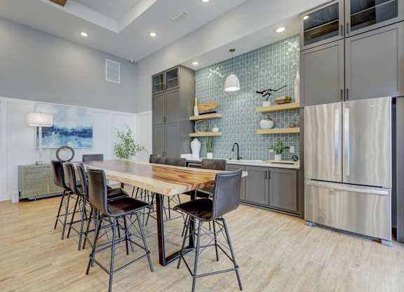a kitchen with stainless steel appliances and a wooden table with chairs at Century Mundy Mill Apartments, Georgia