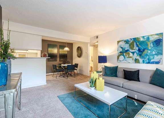 A living room with a grey couch, a white coffee table, and a blue rug. at Grove at St. Andrews, Columbia