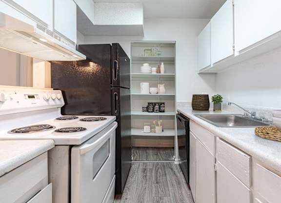 A modern kitchen with white appliances and a black refrigerator. at Grove at St. Andrews, Columbia, 29210