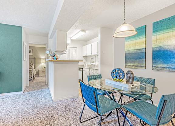 A dining room with a glass table and blue chairs. at Grove at St. Andrews, Columbia