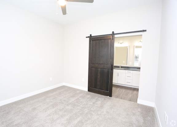 an empty living room with a wooden sliding door to a bathroom at Century Baxter Avenue, Kentucky, 40204