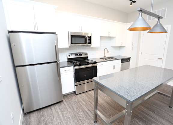 a kitchen with stainless steel appliances and a table at Century Baxter Avenue, Louisville, KY 40204