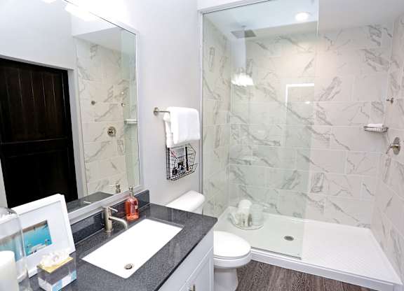 a bathroom with a shower and a sink and a mirror at Century Baxter Avenue, Louisville, KY 40204