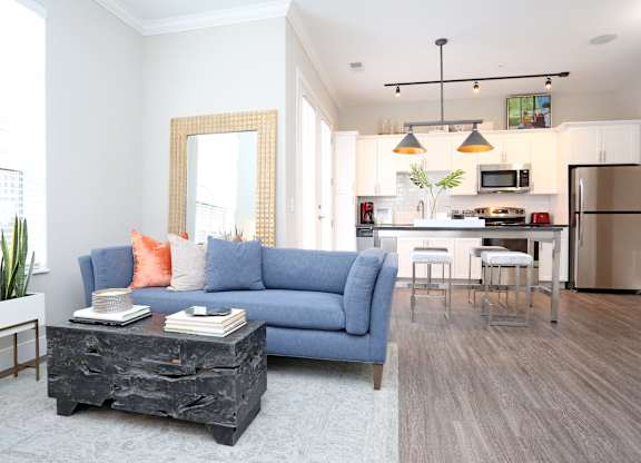 a living room and kitchen with a blue couch and a table at Century Baxter Avenue, Louisville
