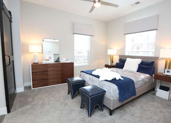 a bedroom with a bed and two night stands and a ceiling fan at Century Baxter Avenue, Louisville, KY