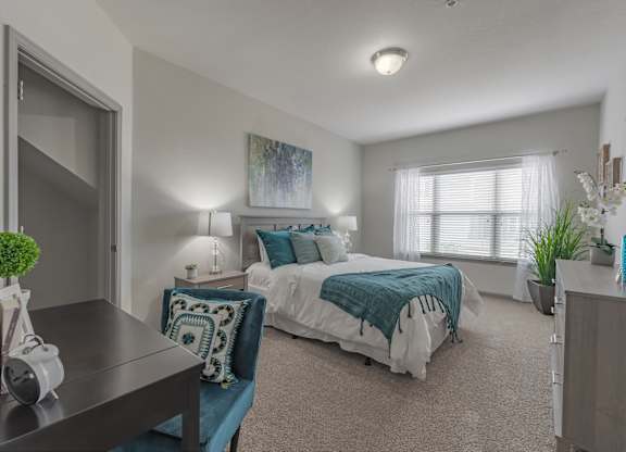 a bedroom with a bed and a desk and a window at Century HomePlace, Prattville, AL