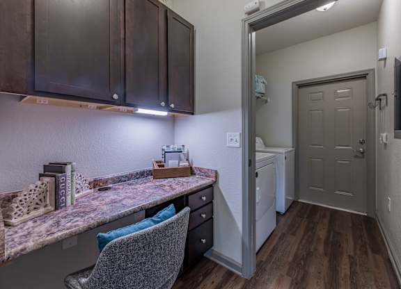 a kitchen with a counter top and a door to a laundry room at Century HomePlace, Prattville