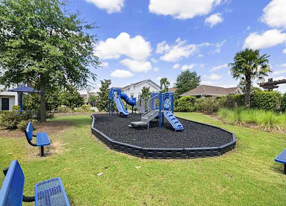 a playground with blue chairs and a black trampoline at Century HomePlace, Prattville
