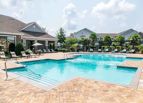 a large swimming pool with chairs around it in front of a house at Century HomePlace, Alabama