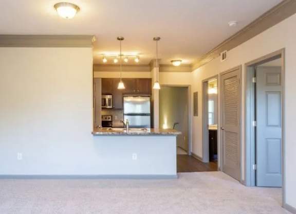 an empty living room with a kitchen and a at Century HomePlace, Prattville