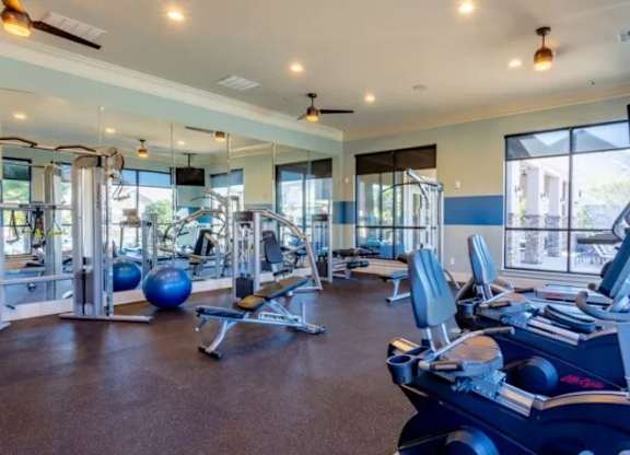 a gym with cardio machines and weights on the floor at Century HomePlace, Prattville, AL 36066