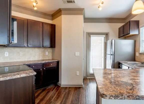 a kitchen with granite counter tops and stainless steel appliances at Century HomePlace, Alabama