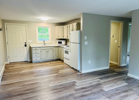 a renovated kitchen with white cabinets and a wood floor at Briarcliff at Quechee, Vermont