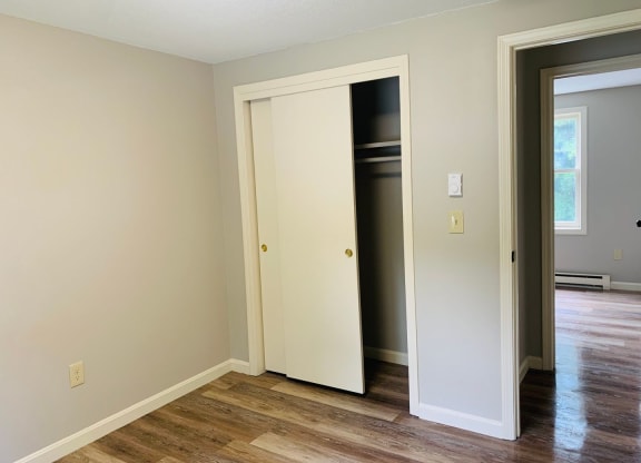 a bedroom with a door open to a closet and a hard wood floor at Briarcliff at Quechee, Quechee