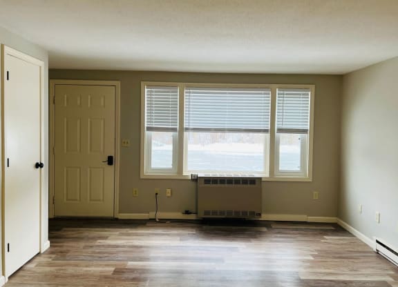 an empty living room with a large window and a door at Briarcliff at Quechee, Vermont, 05059