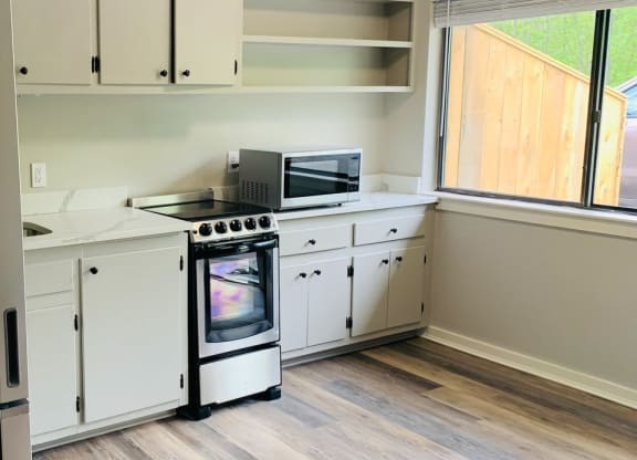 a kitchen with white cabinets and a stove and a window at Briarcliff at Quechee, Quechee, VT 05059