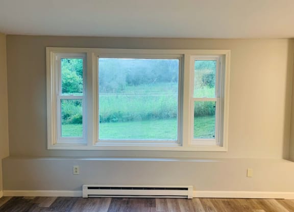 a room with three windows and a wood floor at Briarcliff at Quechee, Quechee, VT