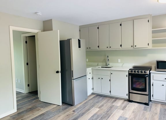 a kitchen with white cabinets and a stove and a refrigerator at Briarcliff at Quechee, Vermont